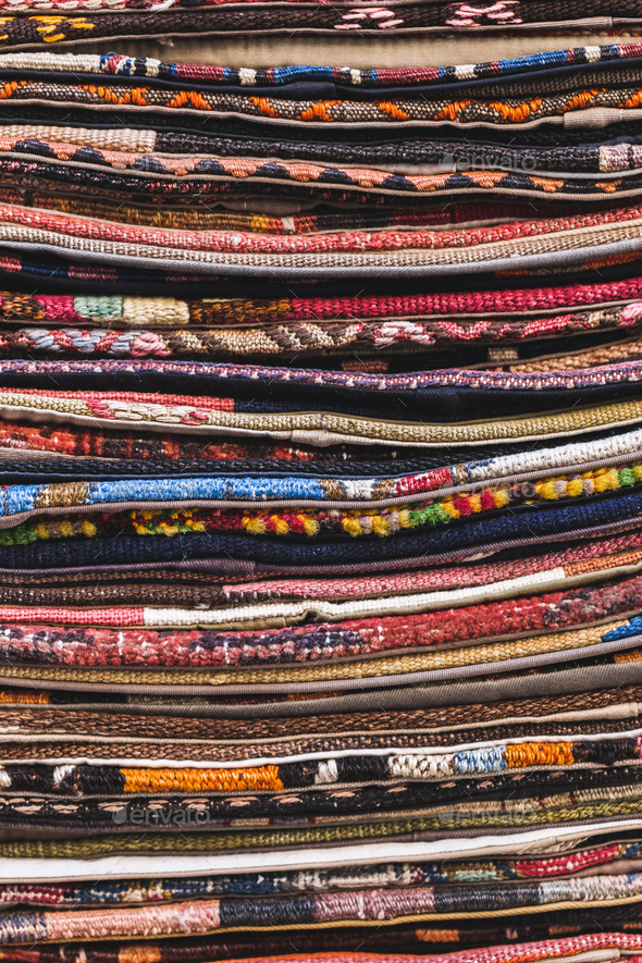 Pile of beautiful handmade carpets on the market in Istanbul Grand Bazaar. Multicolor background