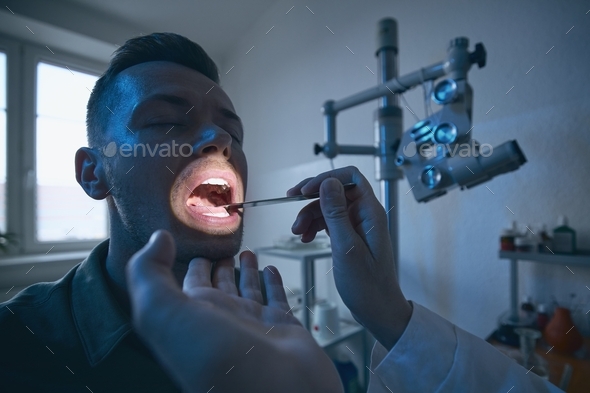 Doctor doing throat examination of young patient