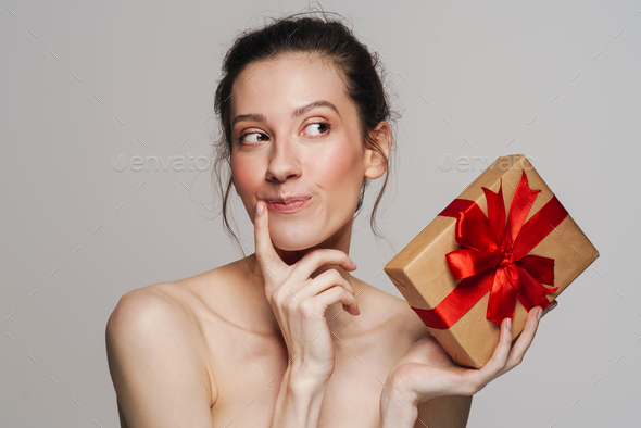 Pleased Half Naked Woman Thinking While Showing Gift Box Stock Photo By