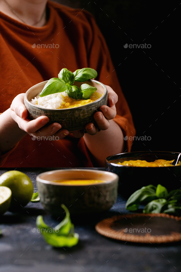 Female holding ceramic bowl of yellow curry - Stock Photo - Images