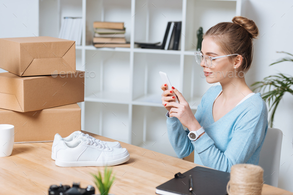 online shop owner taking picture of product on smartphone at home office