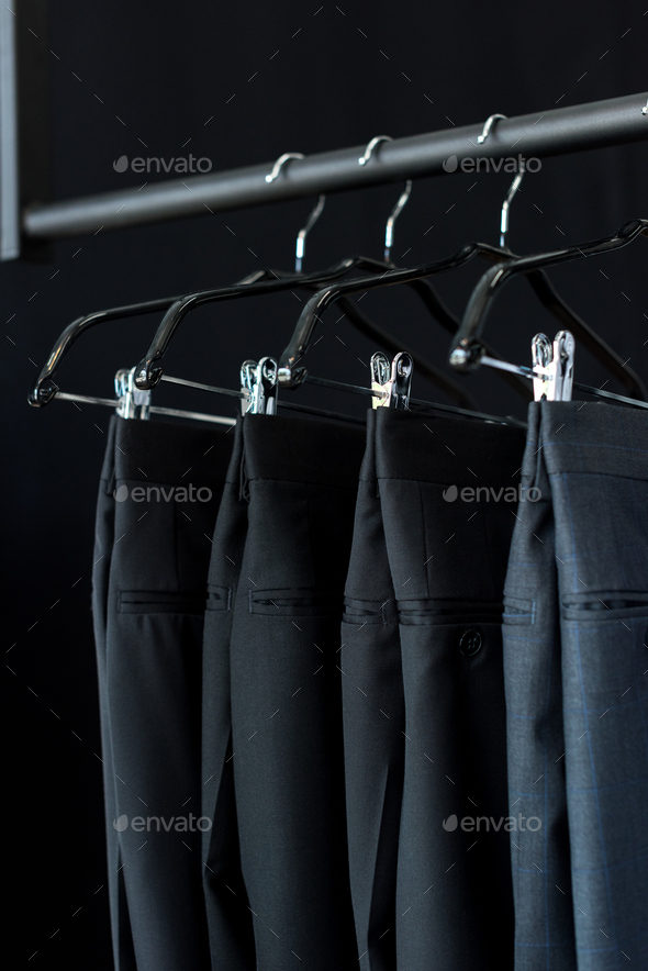 close-up view of fashionable suit pants on hangers in boutique