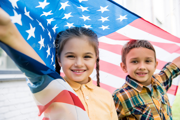 smiling brother and sister with american flag Stock Photo by ...