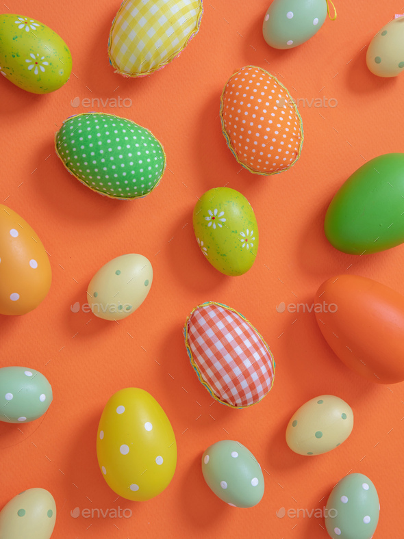 Happy Easter. Pastel orange and green color eggs on orange background,