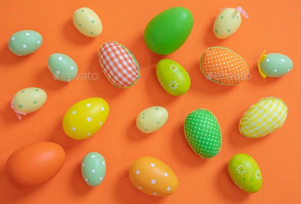 Happy Easter. Pastel orange and green color eggs on orange background