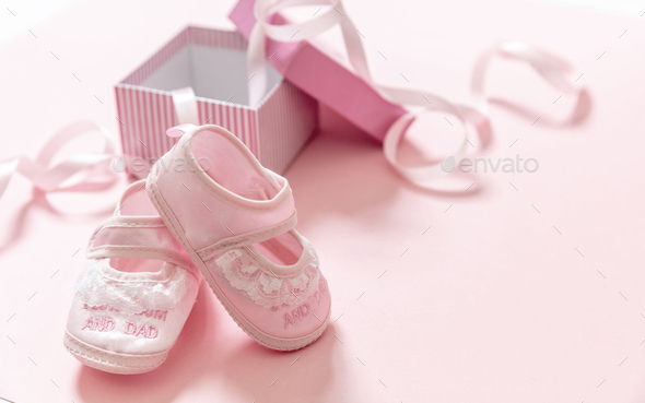 It's a girl announcement. Baby girl pink shoes on pink color background.  Stock Photo by rawf8