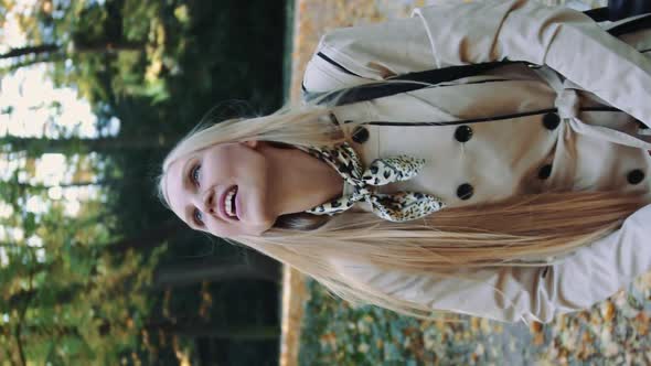 Young Girl Walking in Autumn Park and Throwing Golden Leaves in the Air, Slow Motion alt