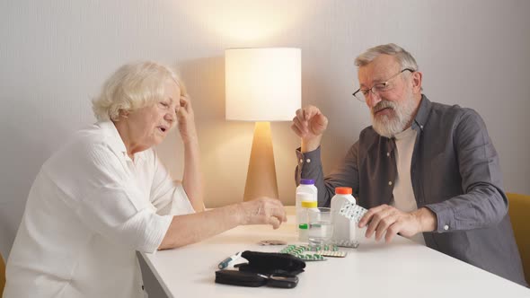 Elderly Couple Understands a Variety of Medicines Sitting in the Kitchen