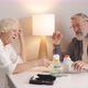 Elderly Couple Understands a Variety of Medicines Sitting in the Kitchen - VideoHive Item for Sale