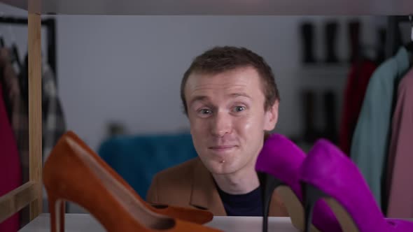 Closeup Shoes on Shelf in Fashion Shop with Joyful Gay Man Appearing and Hiding Back in Slow Motion alt