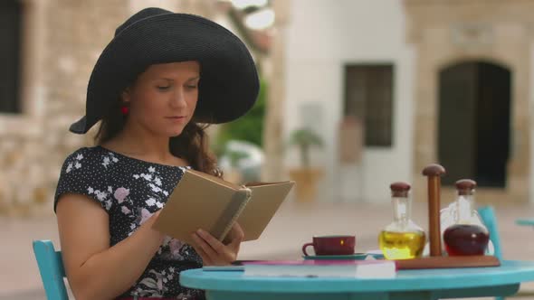 Pretty Woman Reading Old Paper Book in Cafe, Enjoying Rest, Relaxing on Vacation alt