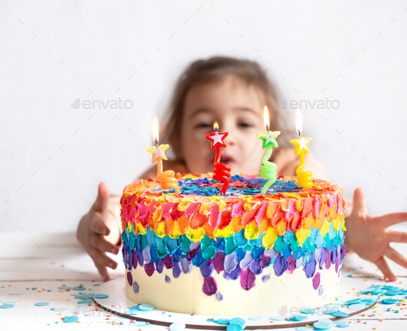 Colorful big handmade birthday cake with burning candles.
