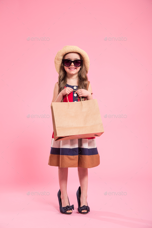 little fashionista on a colored background in mom\'s shoes