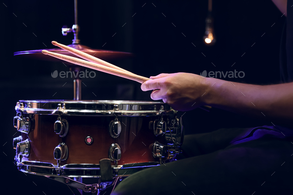 Drummer playing snare drum with sticks close up.