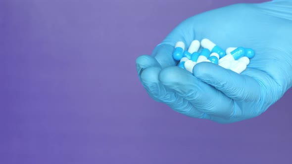 Close Up of Man Hand in Protective Gloves Holding Capsules  alt