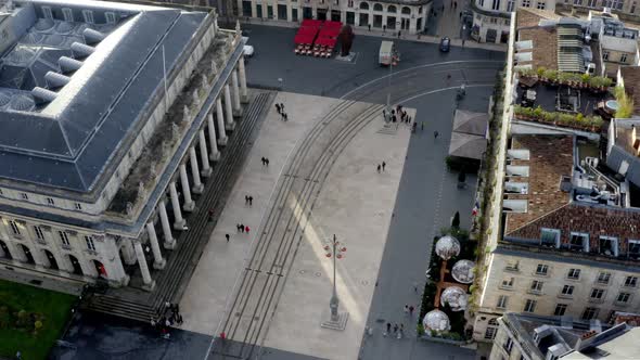 Opera house Grand Theater square with people, vehicles and trolley tram tracks, Aerial orbit reveal alt