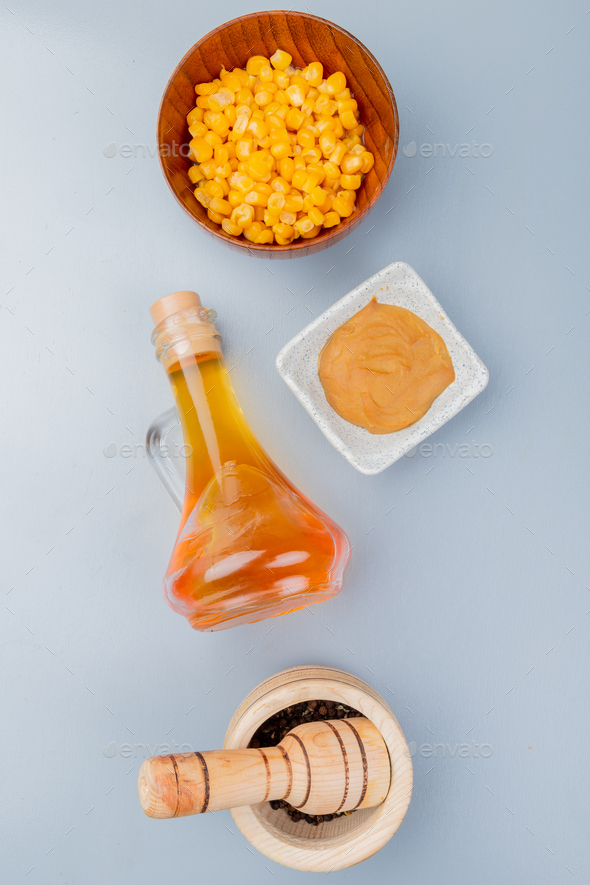 top view of sweet corns on a wooden bowl with mustard sauce with apple vinegar on a white background