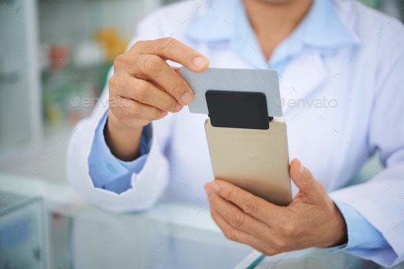 Accepting payment in drugstore - Stock Photo - Images