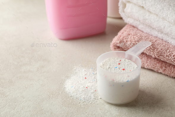 Towels, laundry liquid and scoop with powder, space for text