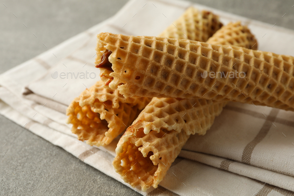 Napkin with wafer rolls with condensed milk on gray background