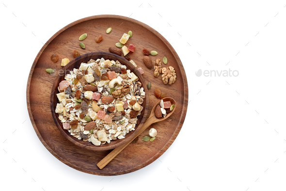 A wooden bowl Muesli with fruit and nut and a spoon isolated on white background - Stock Photo - Images