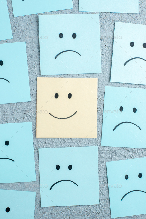 Close up view of many sad and happy emoji faces drawings on gray background with free space