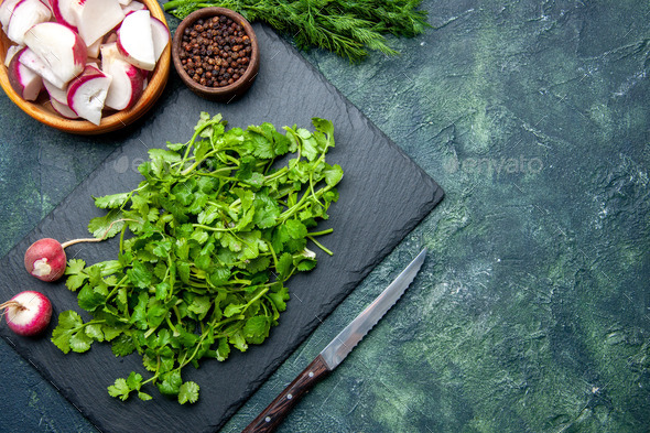 Fresh chopped radishes and a knife on a cutting board on a wooden