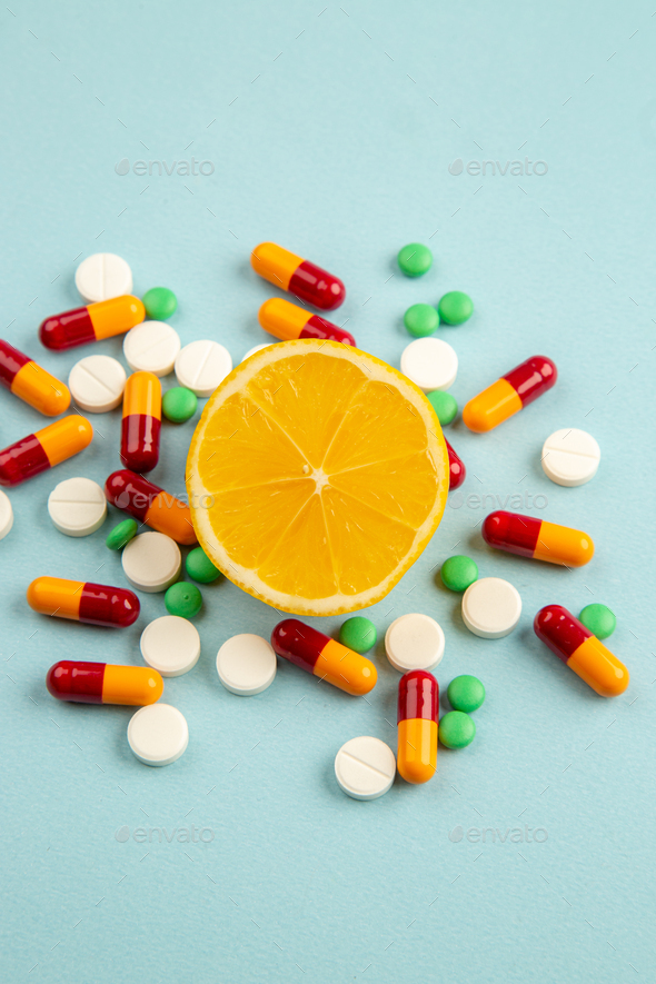 front view different pills with orange slice on light blue background pandemic virus science covid