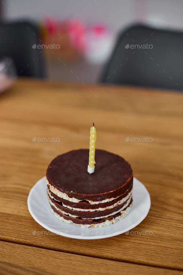 Chocolate birthday cake with one candle on wooden table background at home  Stock Photo by bondarillia