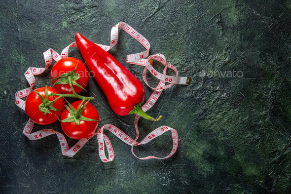 Above view of fresh tomatoes red peppers and meter on dark colors background with free space