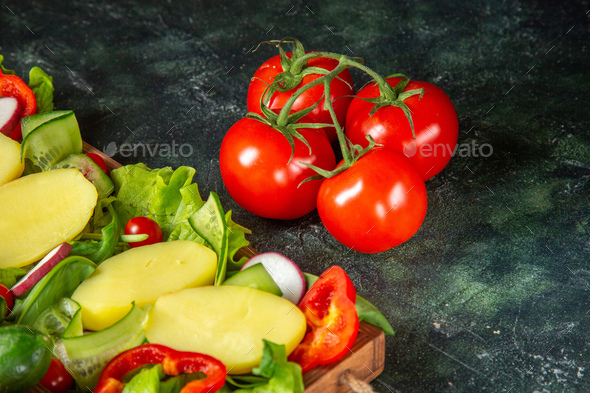 Close up view of chopped vegetables fresh tomatoes with stem meter on a wooden tray on mix colors