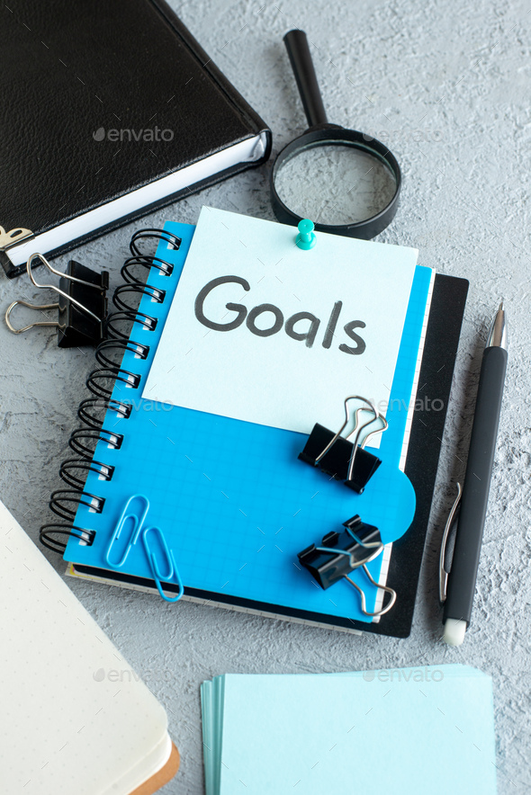front view goals written note with notepad and pen on white background color school copybook