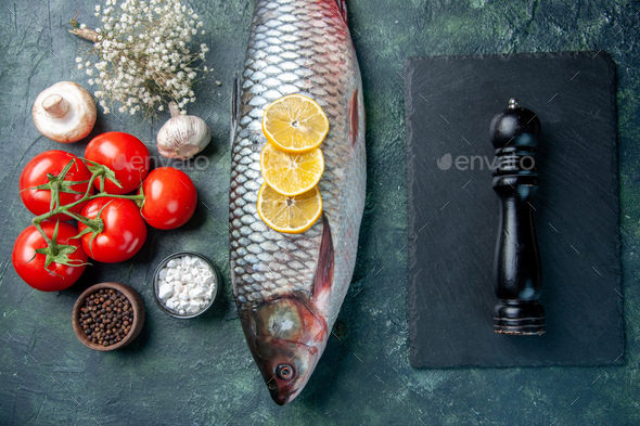 top view fresh raw fish with lemon and tomatoes on dark blue background shark seafood meal ocean