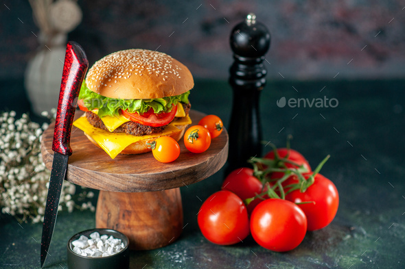 front view tasty meat hamburger with knife tomatoes and pepper shaker on dark background color