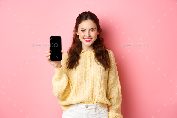 Technology and online shopping. Young smiling woman looking determined, advicing download app - Stock Photo - Images