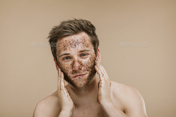 Man using facial scrub