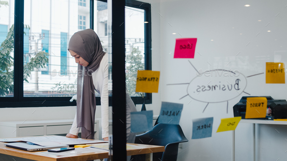 Asia muslim lady drawing work plan think information reminder on paper in new normal office. - Stock Photo - Images