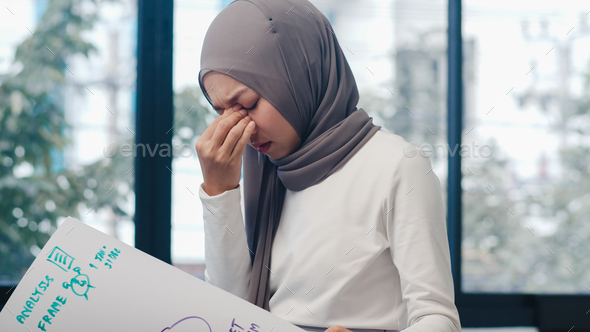 Asia muslim lady drawing work plan think information reminder on paper in new normal office - Stock Photo - Images