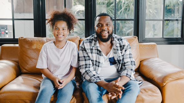 African American family having fun cuddle and video call on laptop