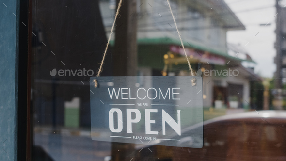 Welcome we\'re open vintage black and white retro sign on a coffee glass door cafe.