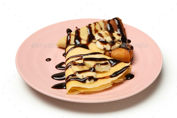 Plate of crepes with chocolate sauce and banana slices isolated on white background