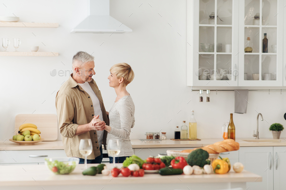 Happy senior couple in love celebrating Valentines day at home together, having romantic dinner - Stock Photo - Images