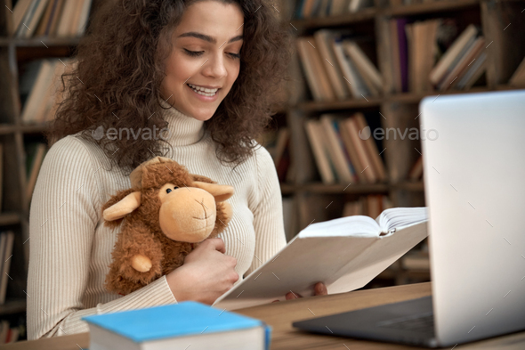 Hispanic woman remote teacher reading fairy tale book teaching children online.