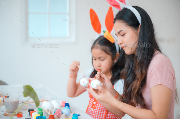 Attractive young woman with little cute girl are preparing for Easter celebration - Stock Photo - Images