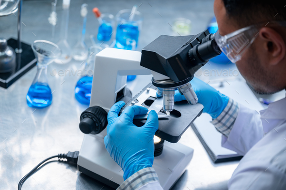 Science and medicine, scientist analyzing and dropping a sample into a glassware - Stock Photo - Images