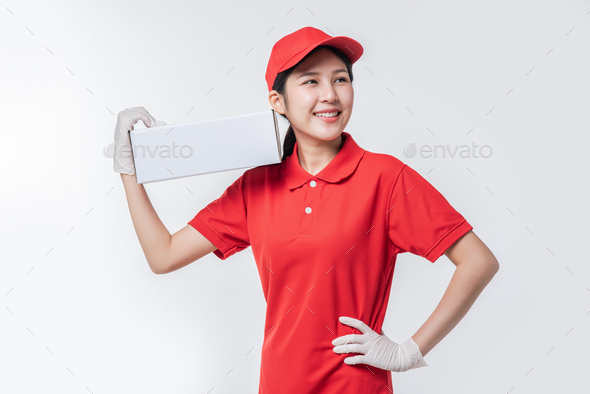 Image of young delivery man in red cap blank t-shirt uniform standing with empty white cardboard.