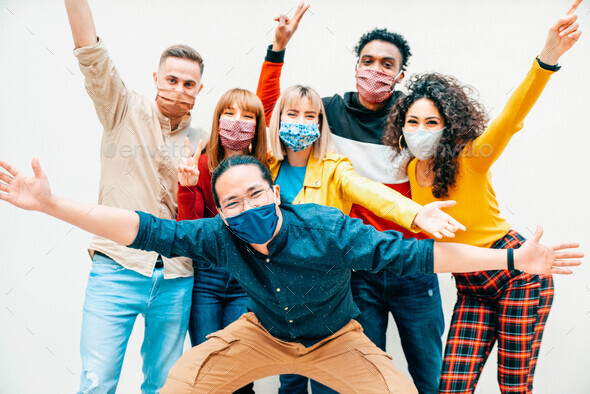 Multicultural people covered by protective face masks smiling at camera