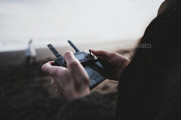 Man controlling a drone by a remote control - Stock Photo - Images