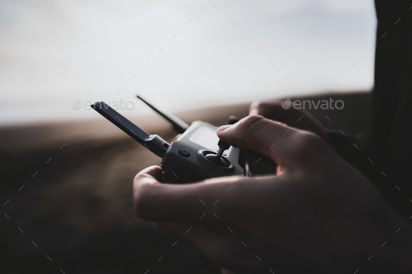 Man controlling a drone by a remote control - Stock Photo - Images