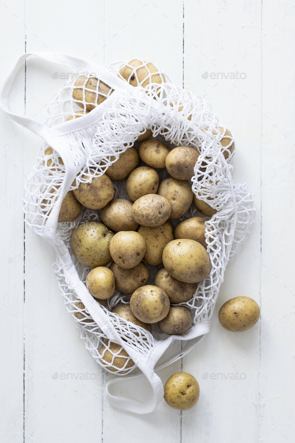 Fresh natural raw potatoes in white net bag